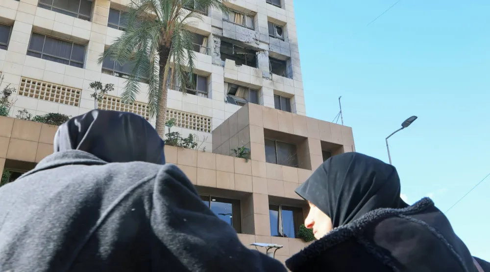 لبنانيتان تقفان أمام مدخل فندق «رامادا» في منطقة الروشة غداة استهداف إسرائيلي لغرفتين في الفندق أسفر عن مقتل 4 أشخاص وإصابة 10 آخرين (إ.ب.أ)