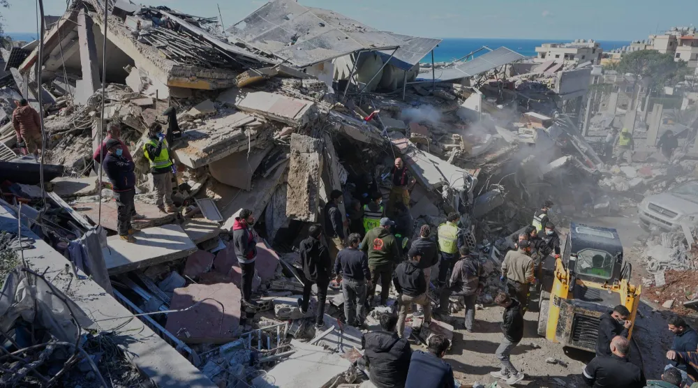 عمال إغاثة يبحثون عن ضحايا في مبنى تعرض لقصف إسرائيلي في بلدة الغازية بجنوب لبنان (أ.ب)