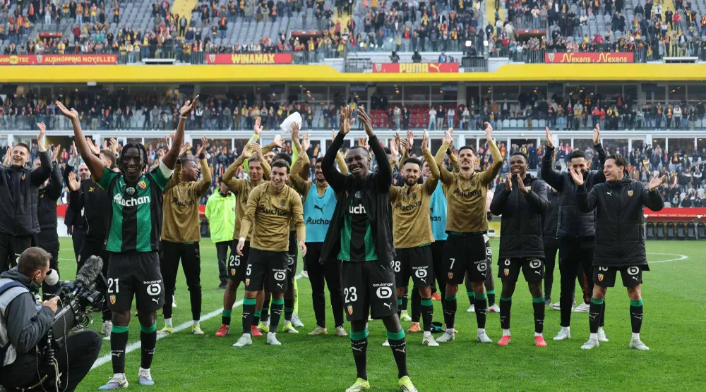 Lens' players celebrate winning the French L1 football match between RC Lens and FC Metz at the Stade Bollaert-Delelis in Lens, northern France on March 8, 2026. (Photo by Francois LO PRESTI / AFP)