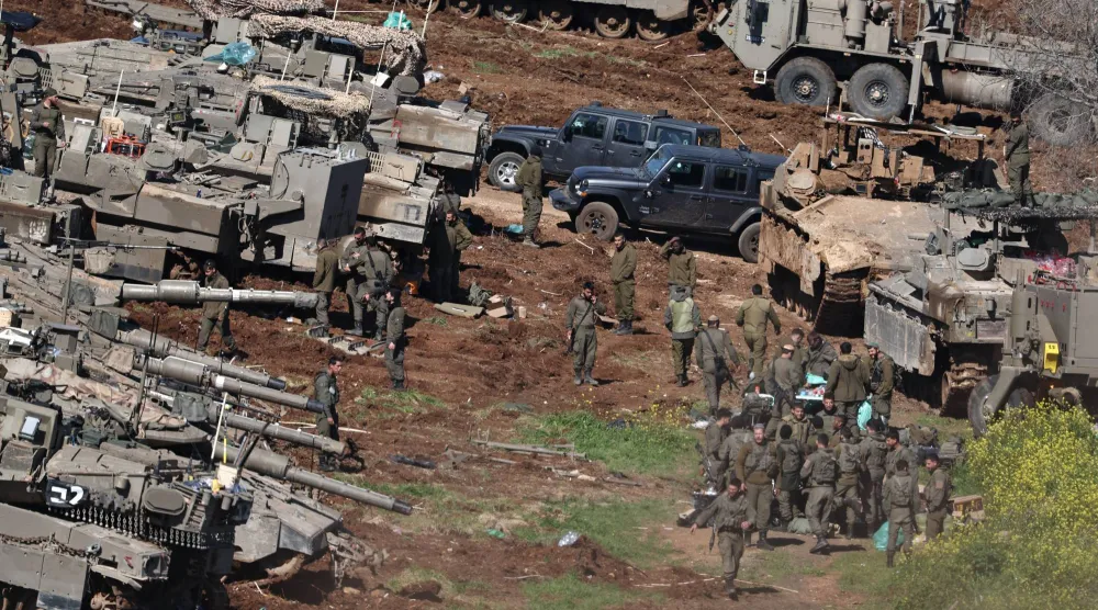 جنود إسرائيليون يقفون إلى جانب دباباتهم في موقع عسكري على الحدود الإسرائيلية اللبنانية (إ.ب.أ)