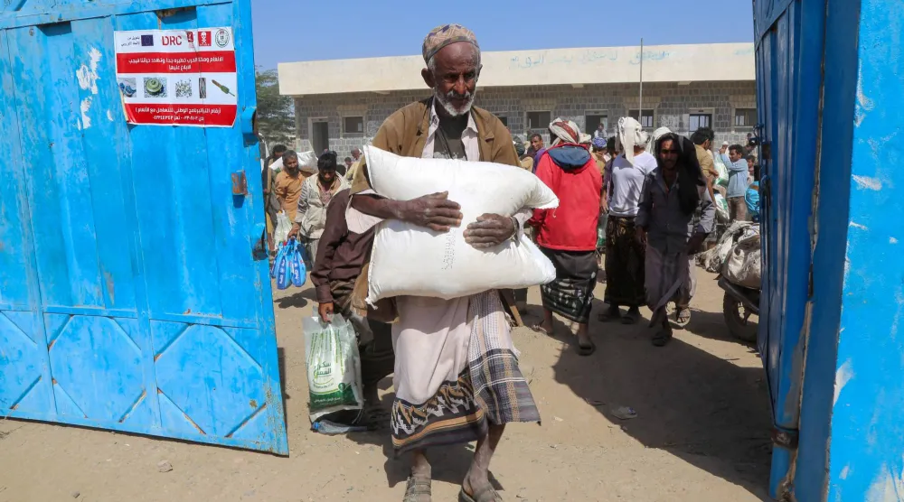 يمني يحصل على معونة غذائية بمحافظة الحديدة حيث يعيش ملايين السكان تحت خط الفقر (أ.ف.ب)