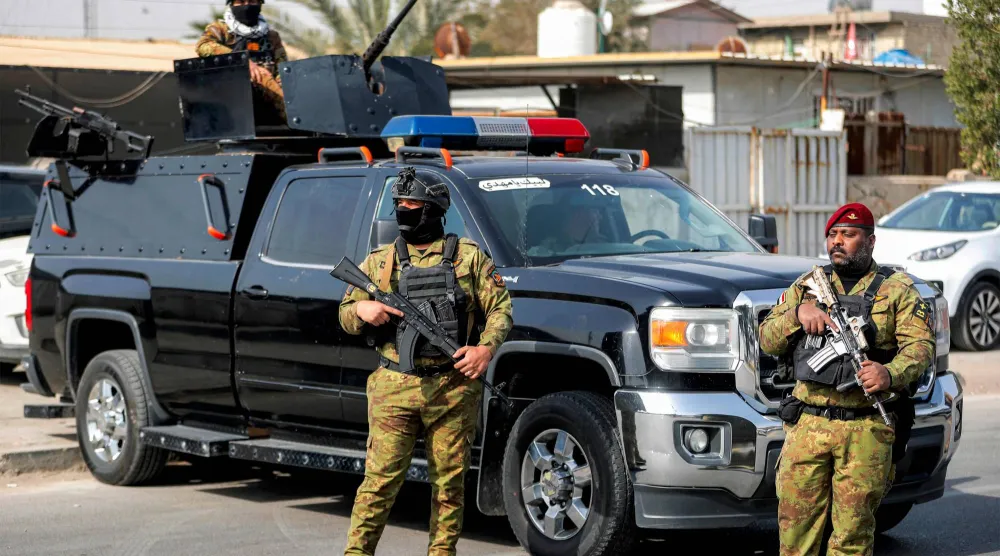 وقفت قوات الأمن العراقية حراسةً خلال موكب جنازة أحد عناصر «الحشد الشعبي» العراقي (أ.ف.ب)