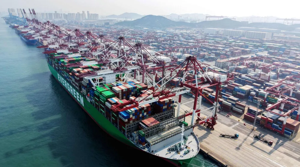 سفينة شحن وحاويات في ميناء بمدينة تشينغداو في مقاطعة شاندونغ بشرق الصين (أ.ف.ب)