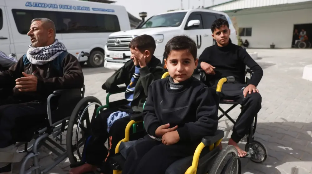 Han Yunus’taki Kızılay Hastanesi avlusunda tedavi için Gazze’den çıkmayı bekleyen Filistinli hastalar tekerlekli sandalyelerde oturuyor. (AFP)