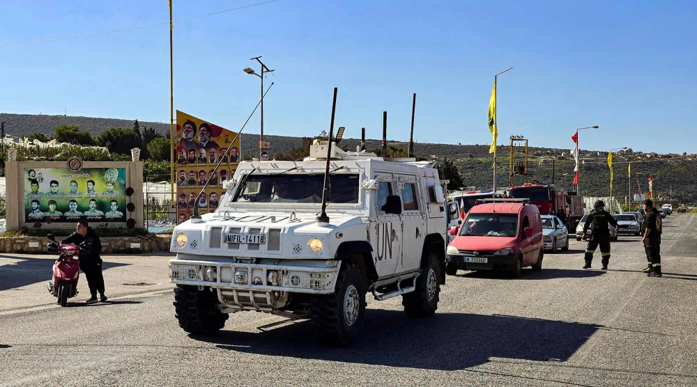 سيارة لـ«اليونيفيل» تواكب أهالي بلدة علما الشعب الحدودية مع إسرائيل بجنوب لبنان الذين أخلوا منازلهم باتجاه العمق اللبناني (أ.ف.ب)