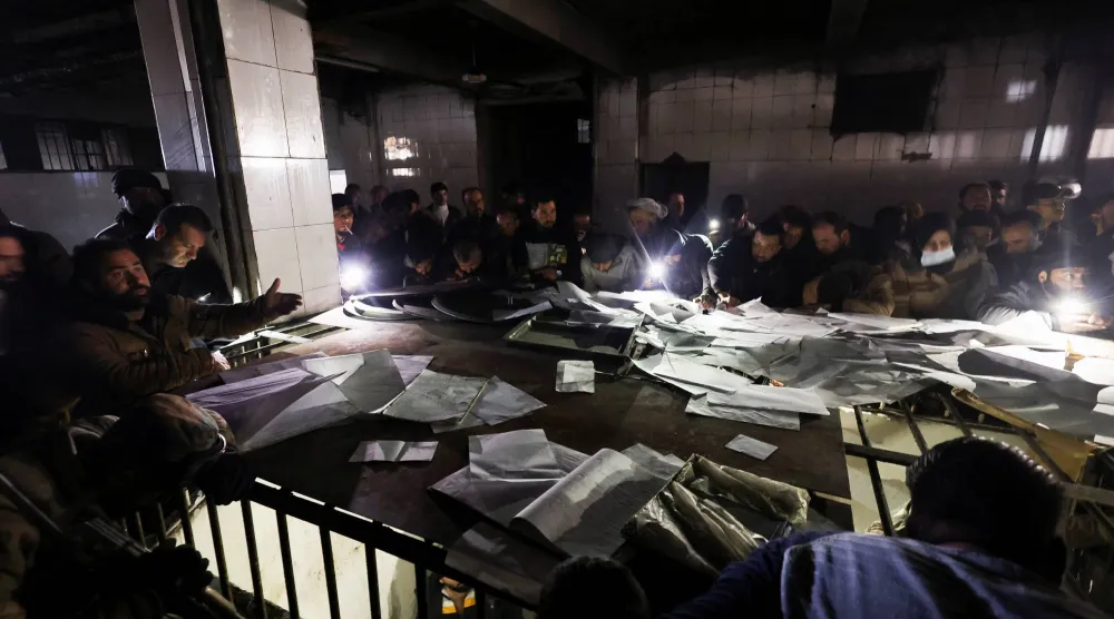 سوريون يبحثون عن ذويهم بين كشوف المعتقلين في سجن بدمشق (رويترز)