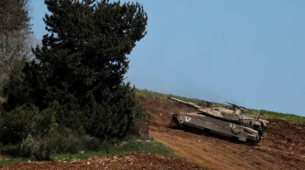 دبابة إسرائيلية تناور على الجانب الإسرائيلي من الحدود مع لبنان (رويترز)