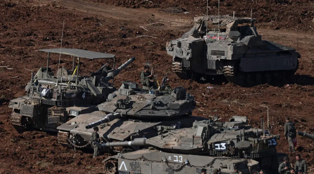 جنود من الجيش الإسرائيلي يتجمعون بالقرب من دبابات منتشرة في موقع في الجليل الأعلى شمال إسرائيل بالقرب من الحدود اللبنانية في 10 مارس 2026 (أ.ف.ب)
