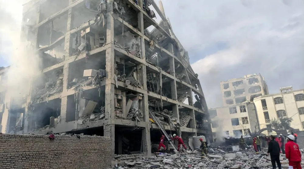 أعضاء من فرق «الهلال الأحمر» الإيراني يوم الثلاثاء في موقع مبنى تضرر بغارة جوية أميركية - إسرائيلية في طهران (د.ب.أ)