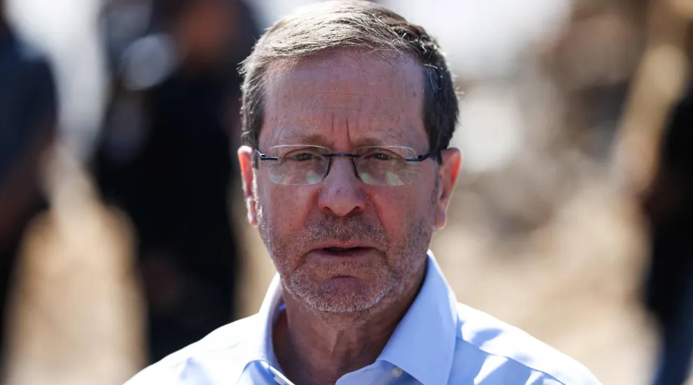 الرئيس الإسرائيلي إسحق هرتسوغ يتحدث إلى وسائل الإعلام في أثناء زيارته لمنطقة تعرضت لضربة إيرانية ليلية في تل أبيب 1 مارس 2026 (أ.ف.ب)
