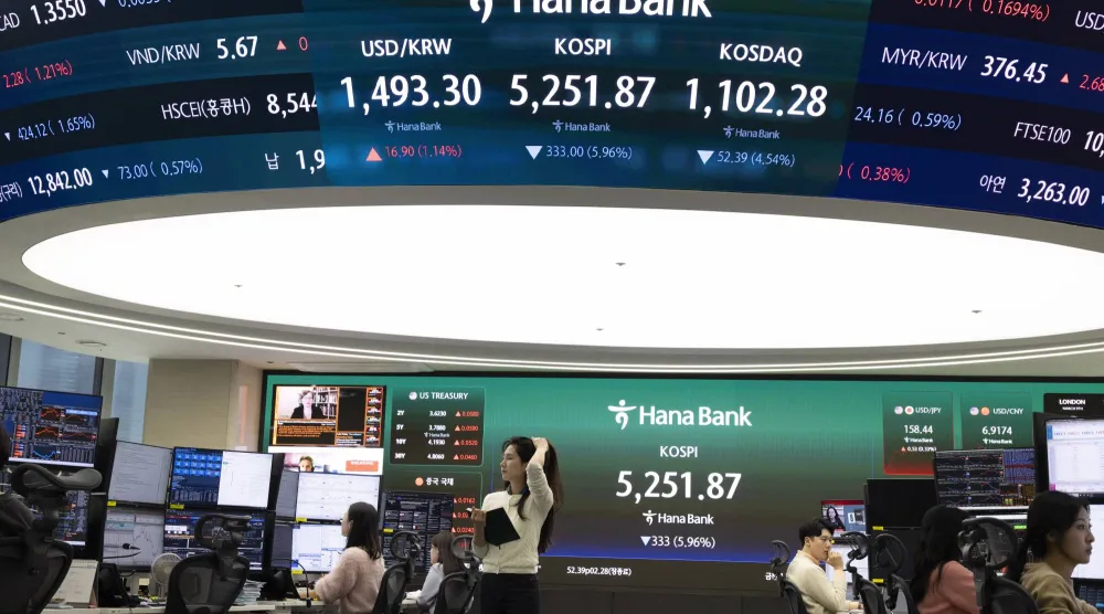 متداولون كوريون جنوبيون أمام شاشات تعرض مؤشرات الأسهم في بنك هانا في سيول (إ.ب.أ)
