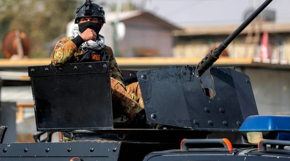أحد أفراد قوات الأمن العراقية يُشرف على برج دفاعي خلال حراسته جنازة أحد عناصر «الحشد الشعبي» العراقي في بغداد (أ.ف.ب)