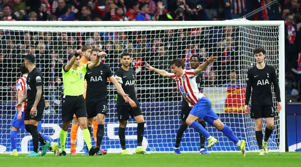  لو نورماند لاعب اتلتيكو يحتفل بالتسجيل وسط حسرة لاعبي توتنهام في مشهد تكرر كثيرا هذا الموسم (رويترز)