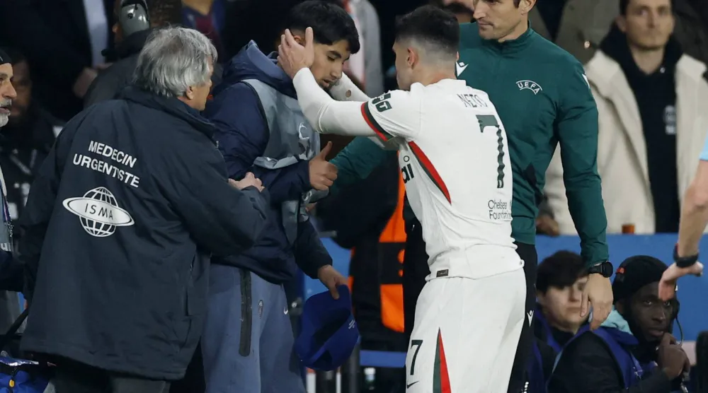 Soccer Football - UEFA Champions League - Round of 16 - First Leg - Paris St Germain v Chelsea - Parc des Princes, Paris, France - March 11, 2026 Chelsea's Pedro Neto checks on ball boy after falling into him Action Images via Reuters/Peter Cziborra