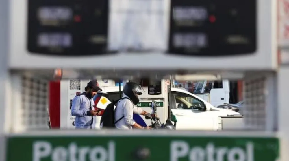 مواطن يغادر بعد تزويد دراجته بالوقود في محطة وقود بنيودلهي (رويترز)