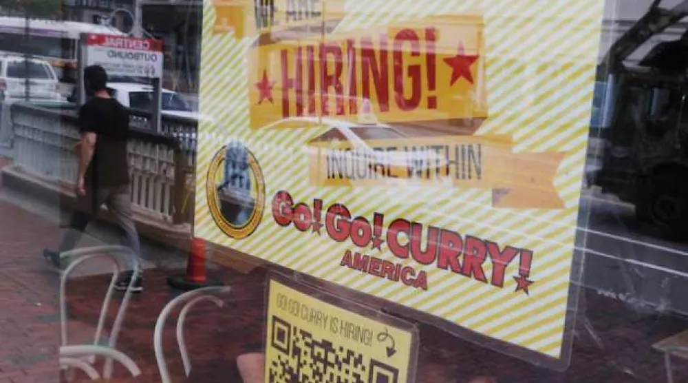 مطعم يعرض لافتة على نافذته كتب عليها «نحن نوظف» في كامبريدج (رويترز)