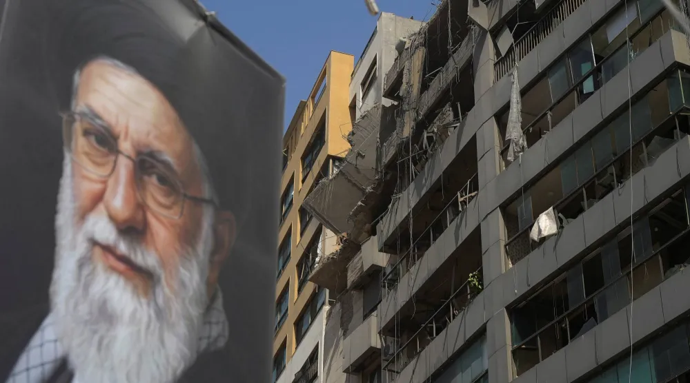 مبنى متضرر في الضاحية الجنوبية لبيروت بعد قصف إسرائيلي استهدف المنطقة... رُفعت عليه صورة كبيرة للمرشد الإيراني السابق علي خامنئي (رويترز)