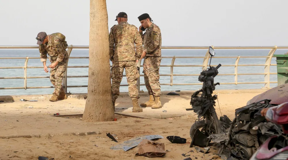 جنود لبنانيون يتفقدون موقع استهداف إسرائيلي على واجهة بيروت البحرية في الرملة البيضاء (د.ب.أ)