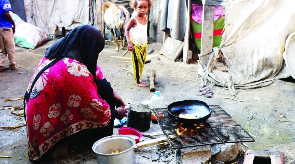 يمنية نازحة تعدّ وجبة فقيرة متواضعة لأطفالها (رويترز)