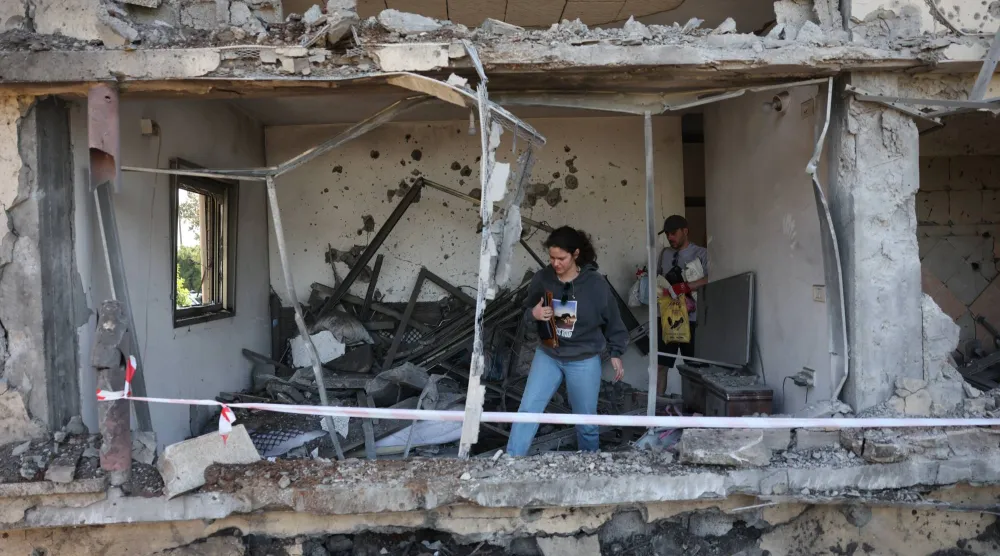 سكان يتفقدون أضراراً بعد أن أصاب صاروخ أطلقه «حزب الله» من لبنان منزلاً بالقرب من مدينة نتانيا إسرائيل 12 مارس 2026 (إ.ب.أ)