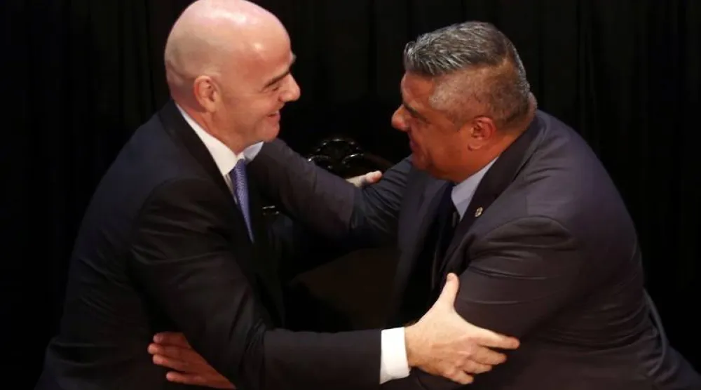 كلاوديو تابيا يصافح رئيس الاتحاد الدولي لكرة القدم جياني إنفانتينو (رويترز)