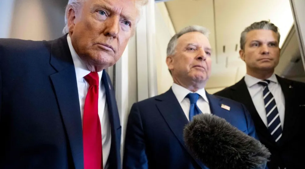 الرئيس الأميركي دونالد ترمب يتحدث إلى وسائل الإعلام وخلفه وزير الدفاع بيت هيغسيث (يميناً) والمبعوث الخاص ستيف ويتكوف (وسطاً) على متن طائرة الرئاسة «إير فورس ون» خلال رحلة من دوفر (أ.ف.ب)