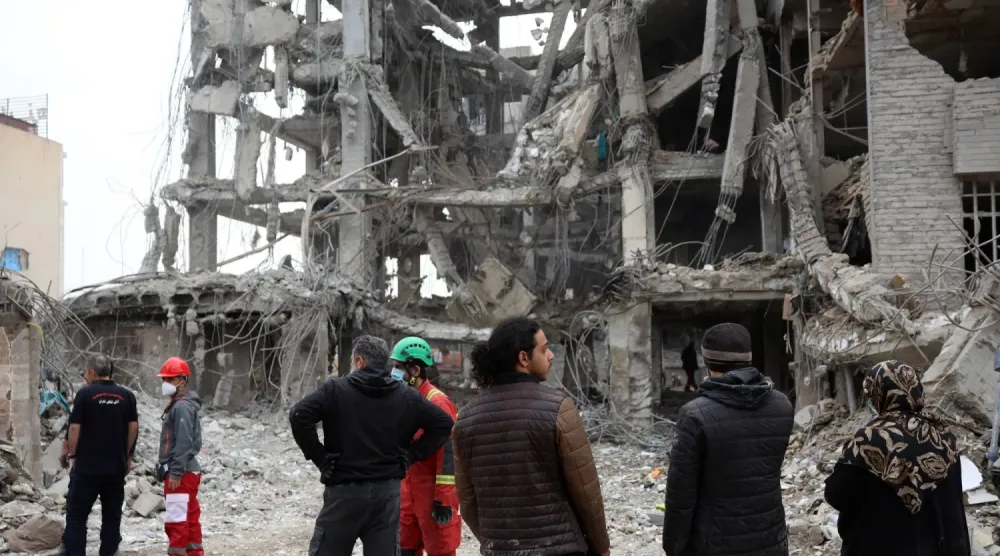 İranlılar dün Tahran'ın merkezinde ABD-İsrail bombardımanı sonucu hasar gören konut binalarını inceliyor (EPA)