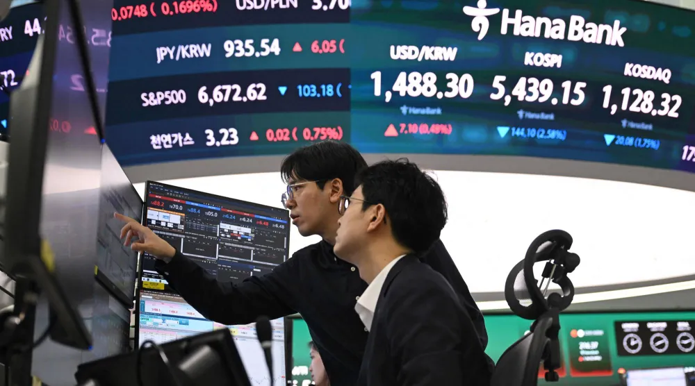 متداولو العملات يراقبون أسعار الصرف داخل مقر بنك هانا في سيول (أ ف ب)