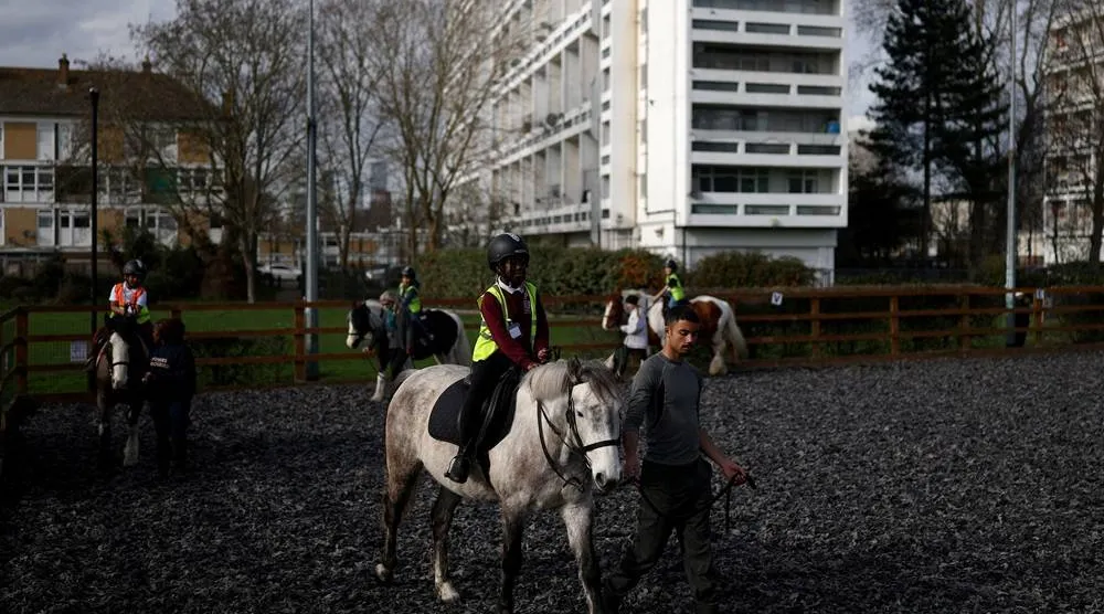 Children ride horses around a paddock during a class at the Ebony Horse Club in Brixton, Britain's most urban riding school, where children from under-privileged communities are taught to ride horses, in London, Britain, March 10, 2026. (Reuters)