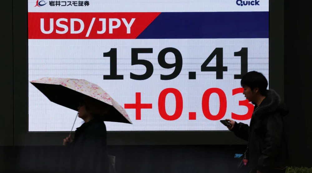 مشاة يمرون أمام شاشة تعرض حركة الين الياباني مقابل الدولار في وسط العاصمة اليابانية طوكيو (رويترز)