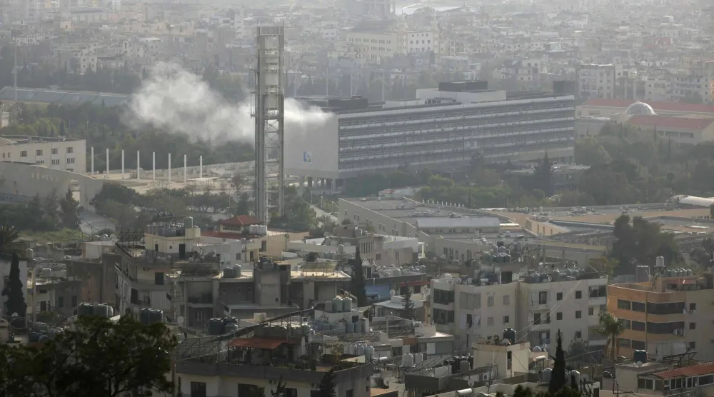 الدخان يتصاعد جراء استهداف حرم الجامعة اللبنانية في منطقة الحدت على أطراف الضاحية الجنوبية لبيروت (أ.ف.ب)