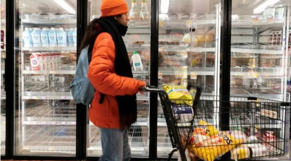 يمر أحد المتسوقين بجوار قسم الألبان في متجر بقالة في واشنطن (رويترز)