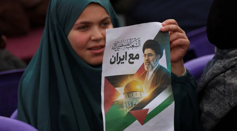 فلسطينية تحمل صورة لمجتبى خامنئي خلال إحياء «يوم القدس» في غزة (رويترز)