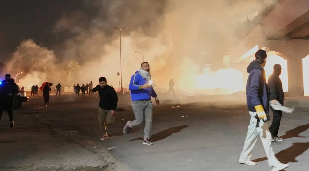 قوات الأمن تطلق الغاز المسيل للدموع لتفريق احتجاج عند جسر يؤدي إلى المنطقة الخضراء حيث تقع السفارة الأميركية في بغداد (أ.ب)