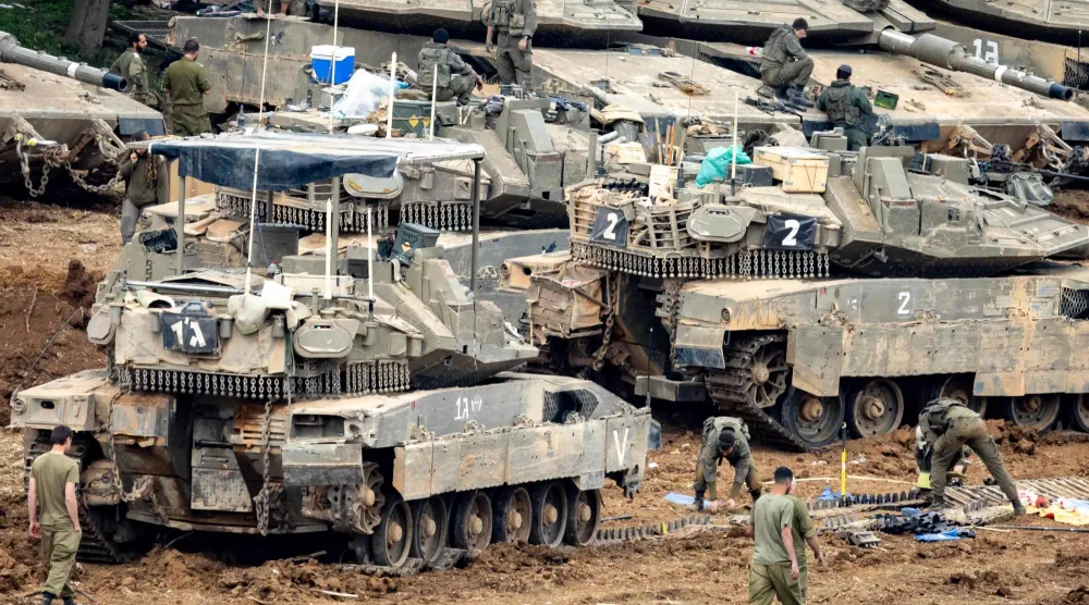 جنود إسرائيليون يجهزون دباباتهم في الجليل الأعلى بشمال إسرائيل قرب الحدود مع لبنان (أ.ف.ب)