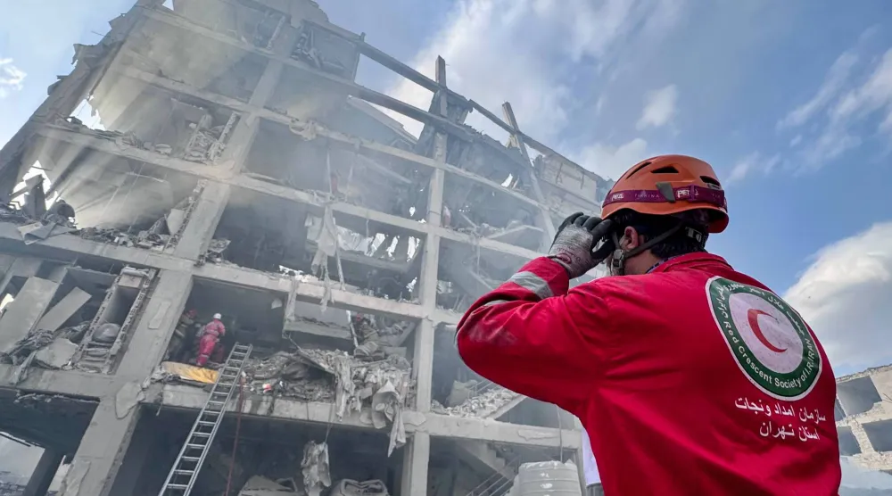 FILED - 10 March 2026, Iran, Tehran: A member of the Iranian Red Crescent Society (IRCS) rescue teams works at the site of a building damaged in a US-Israeli airstrike in Resalat Square. Photo: -/ZUMA Press Wire/dpa