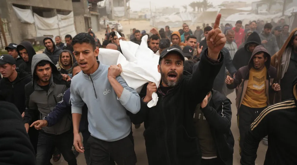 مشيعون يحملون جثمانَي ضابطين فلسطينيين قُتلا في خان يونس (أ.ب)