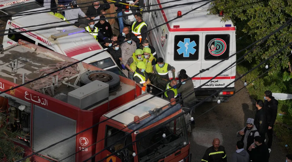 عمال الإنقاذ ينقلون جثة من شقة دمرتها غارة جوية إسرائيلية في مدينة صيدا الساحلية الجنوبية في لبنان (أ.ب)