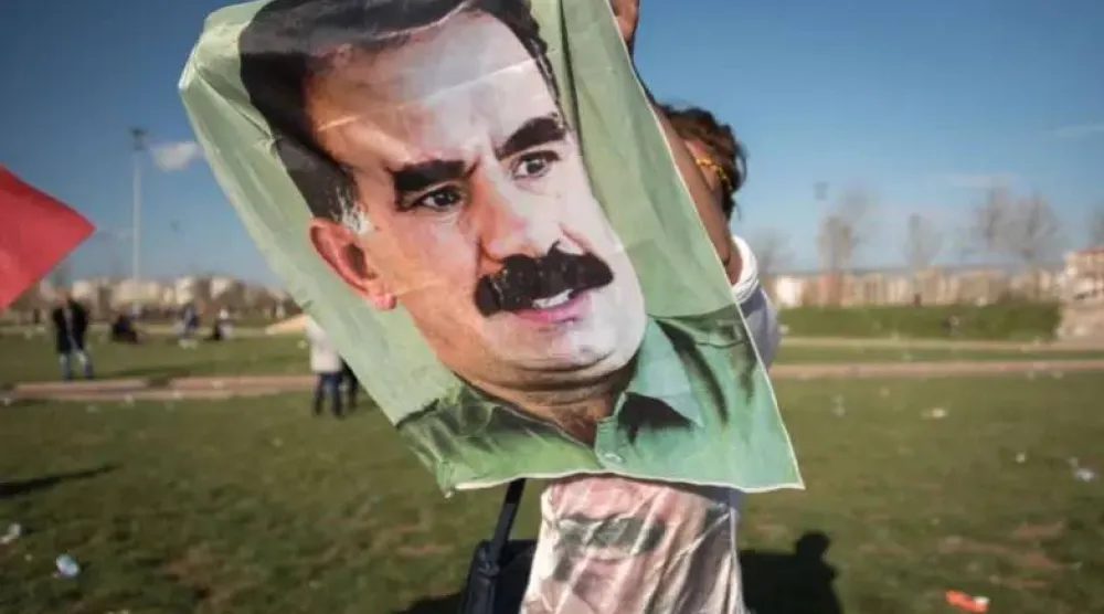 شاب كردي يرفع ثورة لزعيم «حزب العمال الكردستاني» عبد الله أوجلان خلال تجمع في تركيا للمطالبة بإطلاق سراحه (رويترز)