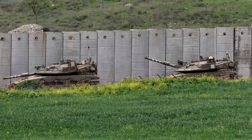 دبابتان إسرائيليتان تنتشران بمحاذاة الجدار الفاصل مع لبنان خلال قتال مع «حزب الله» (إ.ب.أ)