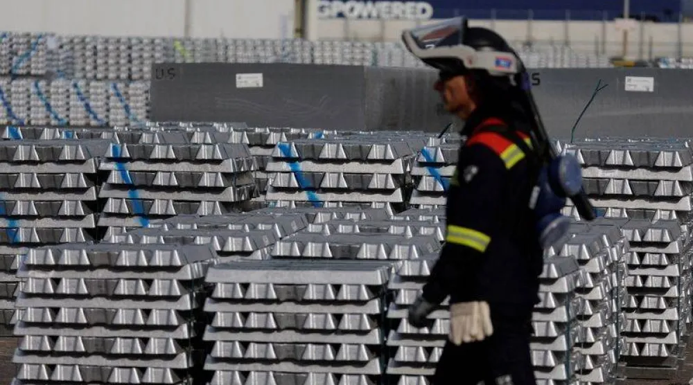 عامل يمر بجوار مخزن سبائك الألمنيوم (رويترز)