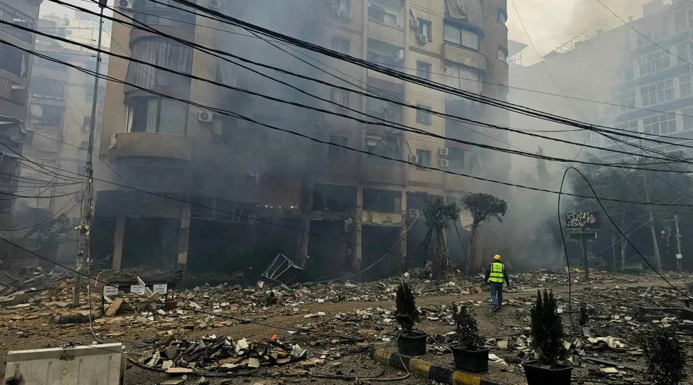 وصل أحد رجال الإنقاذ إلى موقع غارة جوية إسرائيلية استهدفت مجمعاً سكنياً في ضاحية حارة حريك جنوب بيروت (أ.ف.ب)