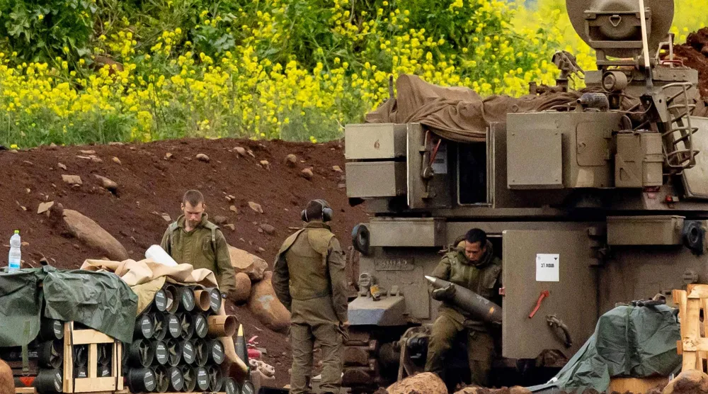 جنود إسرائيليون يُحمّلون قذائف في مدفع هاوتزر ذاتي الحركة يُطلق قذائف باتجاه جنوب لبنان من موقع في الجليل الأعلى شمال إسرائيل قرب الحدود (أ.ف.ب) 