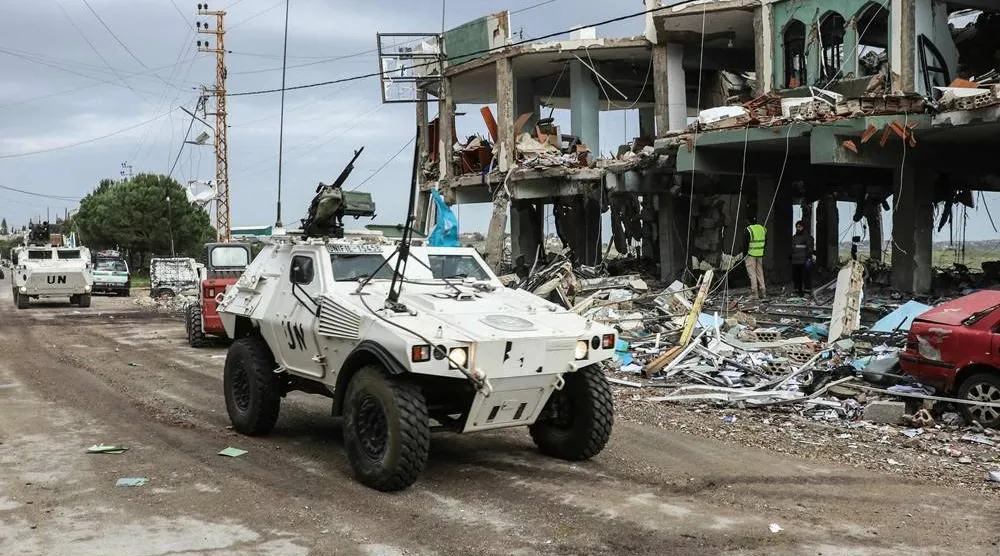 United Nations peacekeepers with the UN Interim Force in Lebanon (UNIFIL) drive past a destroyed healthcare center building in the aftermath of an Israeli strike in the southern Lebanese town of Burj Qalawiya on March 14, 2026. (AFP)