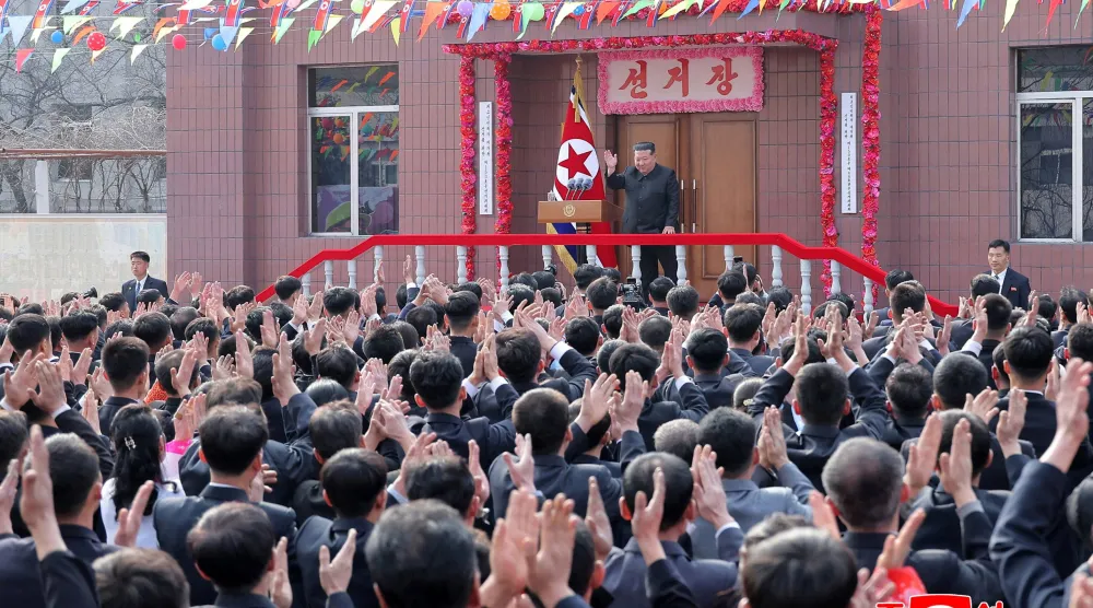 الزعيم الكوري الشمالي كيم جونغ أون يحيي الناس خلال زيارة لمنجم فحم يديره عمال شباب للإدلاء بصوته في انتخابات الجمعية الشعبية العليا بكوريا الشمالية (رويترز)