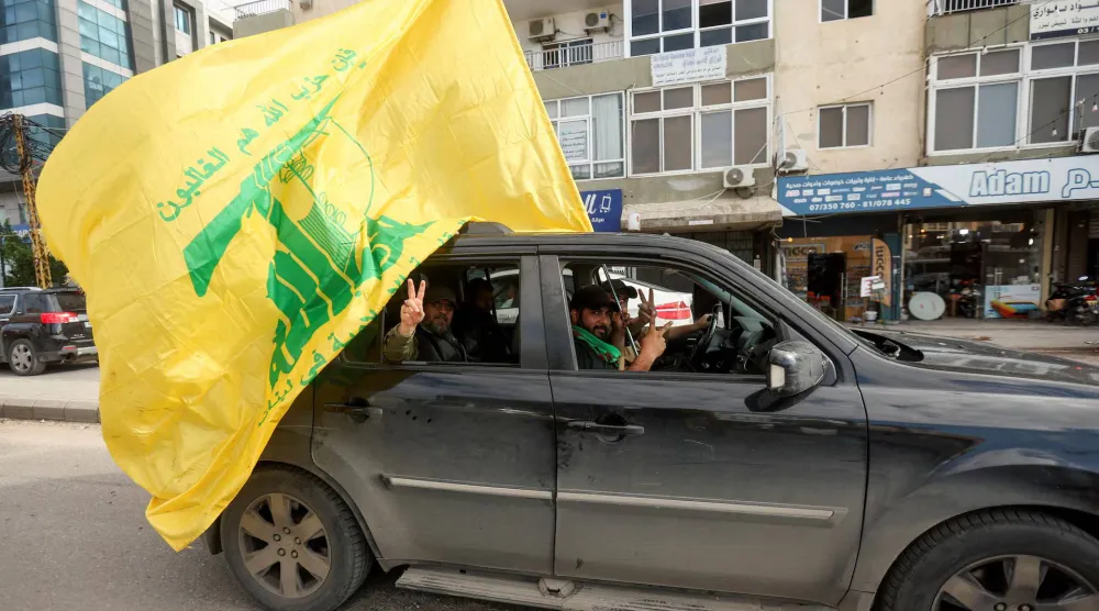 سيارة بداخلها مؤيدون لـ«حزب الله» تمر في مدينة صور بجنوب لبنان يوم 28 نوفمبر 2024 (رويترز)