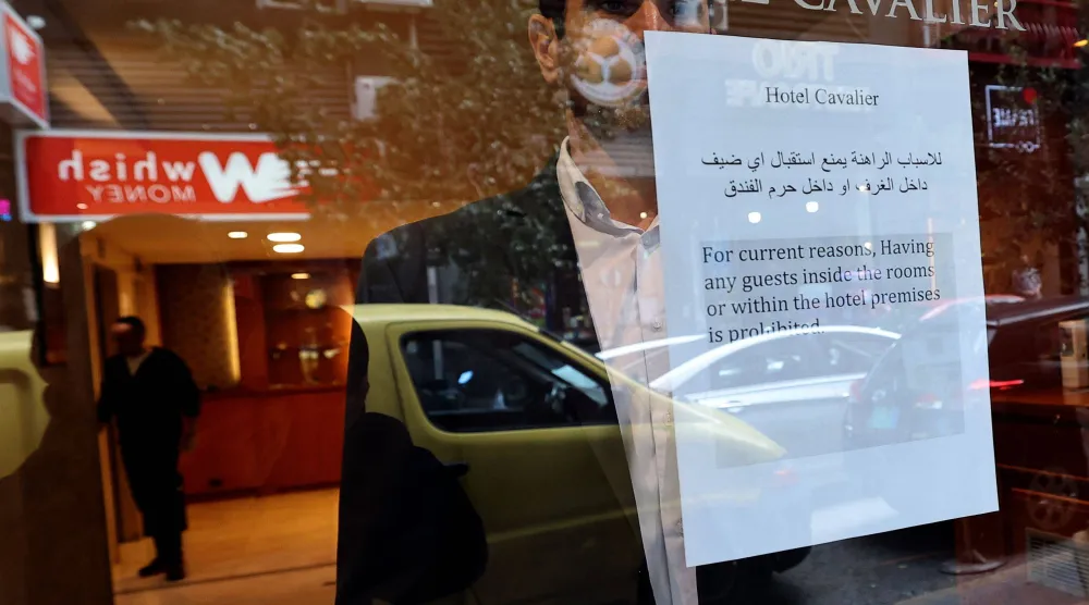 إشعار مطبوع ملصق بالقرب من نافذة أحد الفنادق يُعلم النزلاء بأنه ممنوع عليهم زيارة الفندق بسبب حالة الحرب في بيروت... 16 مارس 2026 (أ.ف.ب)