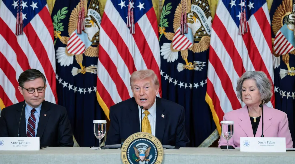 الرئيس الأميركي دونالد ترمب، محاطاً برئيس مجلس النواب مايك جونسون ورئيسة موظفي البيت الأبيض سوزي وايلز، يتحدث خلال فعالية بالبيت الأبيض في العاصمة واشنطن، 16 مارس 2026 (رويترز)