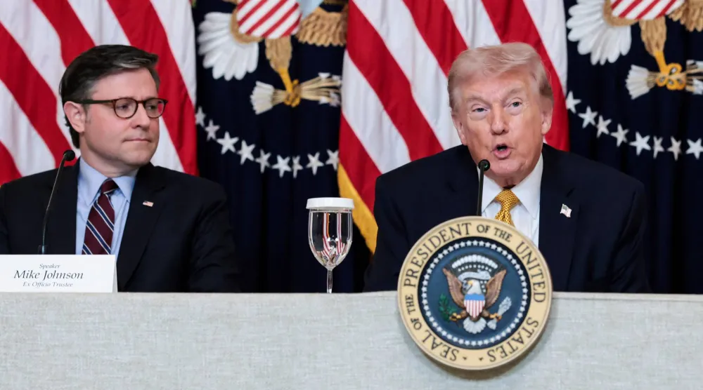 رئيس مجلس النواب الأميركي مايك جونسون يستمع إلى الرئيس الأميركي دونالد ترمب أثناء حديثه في مأدبة غداء مع أعضاء مجلس إدارة مركز كينيدي بالقاعة الشرقية في البيت الأبيض (رويترز)