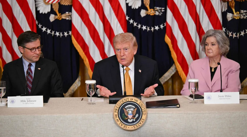الرئيس الأميركي دونالد ترمب بين سوزي وايلز ورئيس مجلس النواب مايك جونسون (أ.ف.ب)